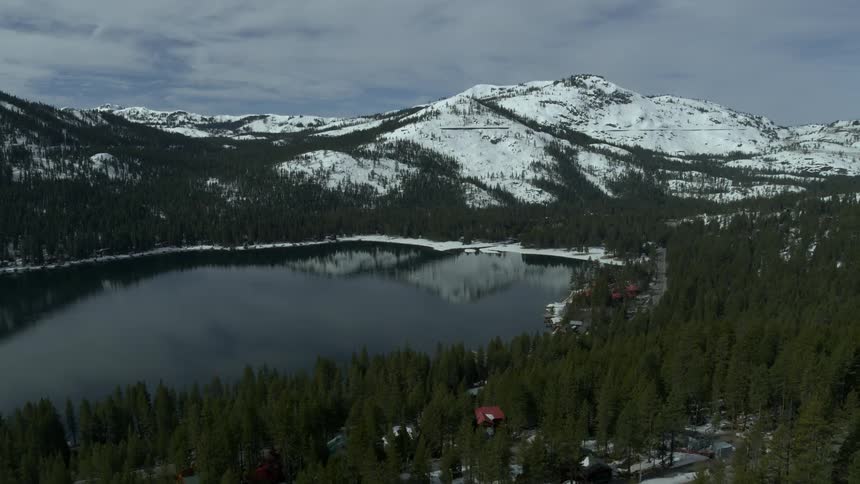 Snow capped mountains reflect in a body of water