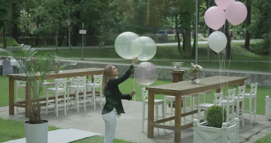 A woman is grabbing some balloons