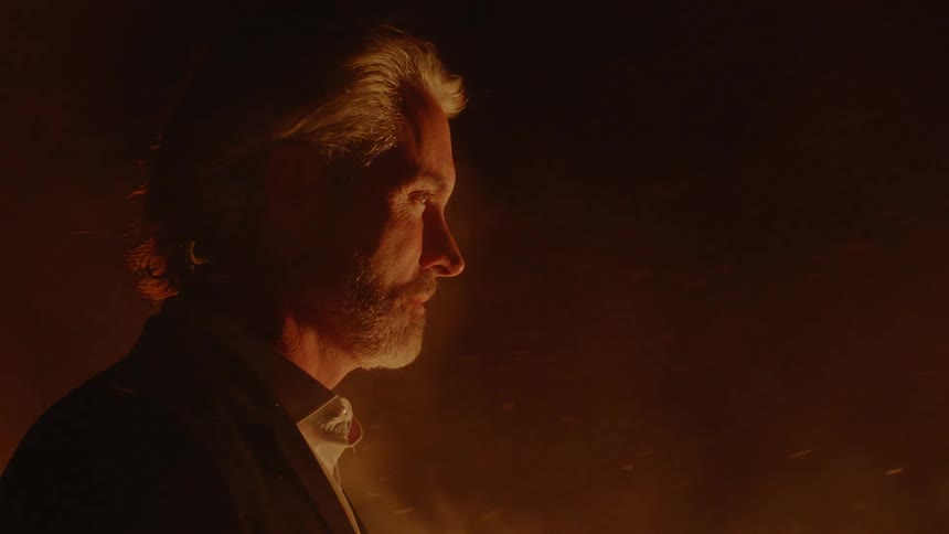 A man and woman surrounded by fire and ash
