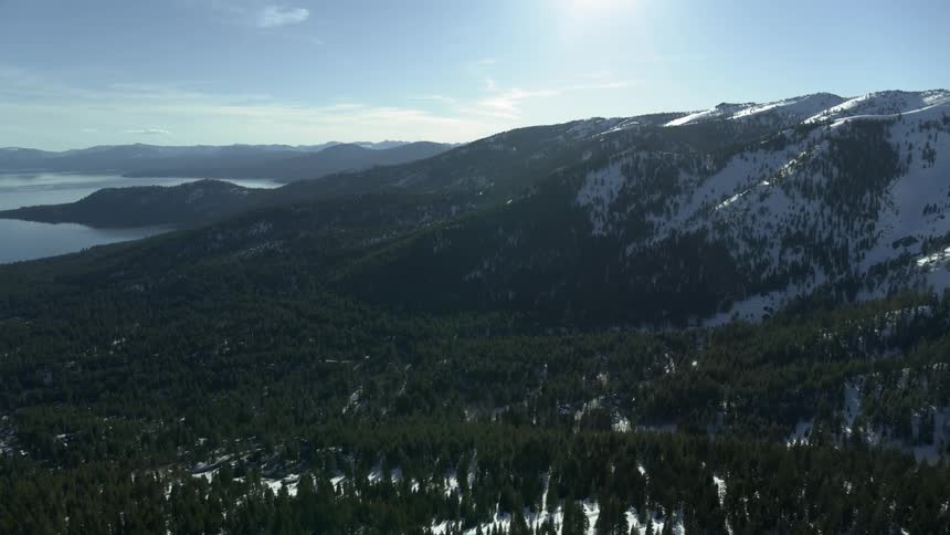 Snow capped mountain tops beside a body of water
