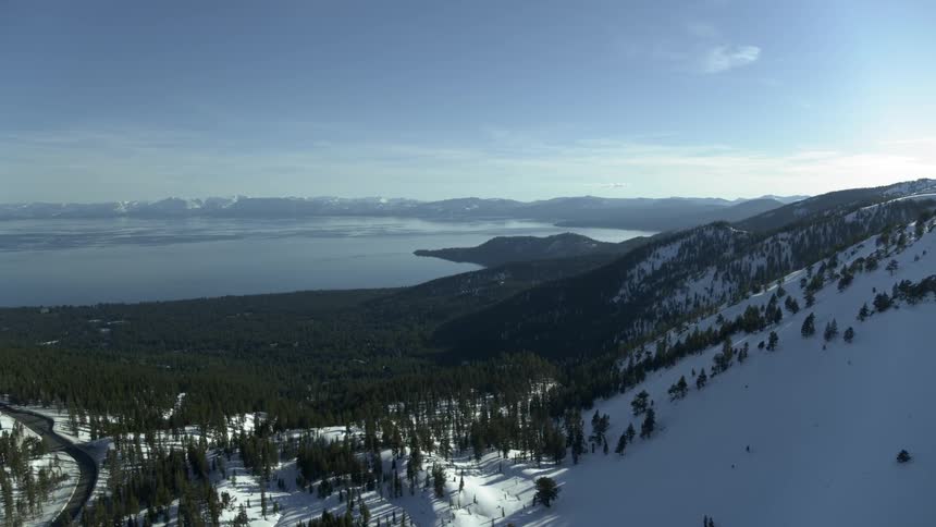 A body of water surrounded by trees and mountains