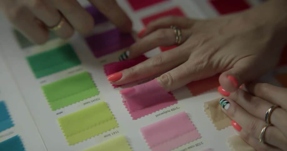 Two people look over fabric colors