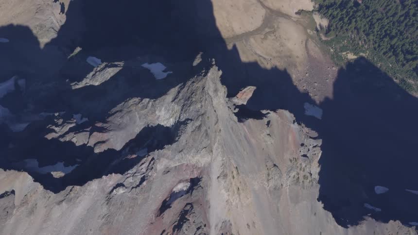 A grey mountain range over a shadowy valley
