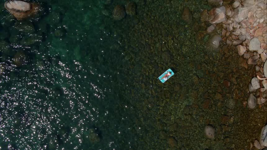 Woman Sunbathing On Raft In Water