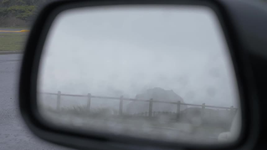 A view of a foggy day out of a car mirror