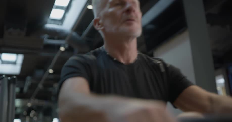 A man using a rowing machine in a gym