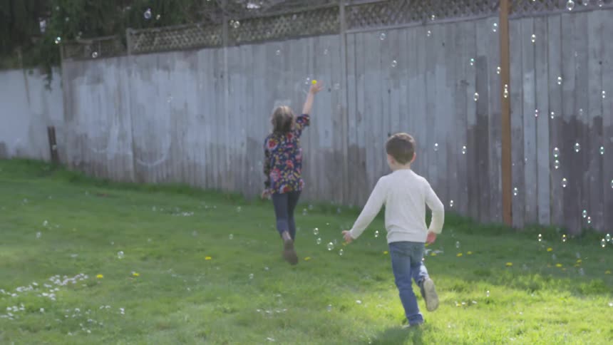 Children running around with bubbles