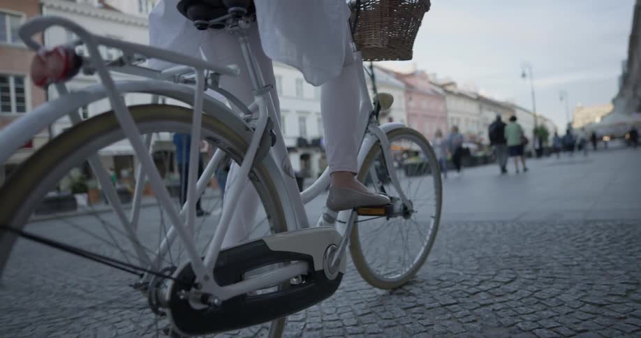 A woman is riding a bike on a sidewalk outside
