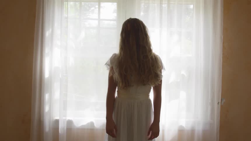 A woman standing in front of a window