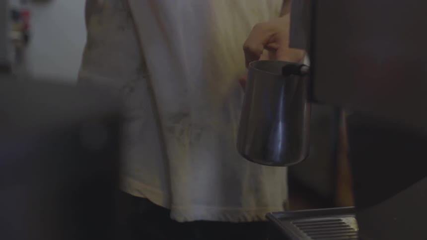 A person is pouring a drink into a metal mug