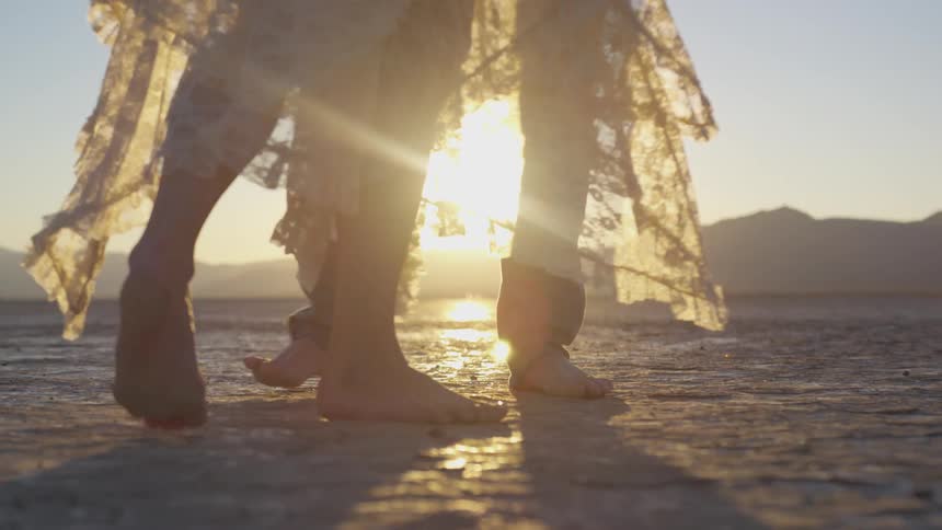 Man and woman stepping around each other in a sunny desert