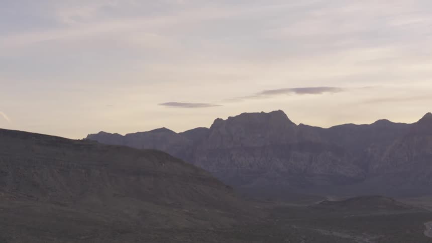 A mountain range next to a dirt road