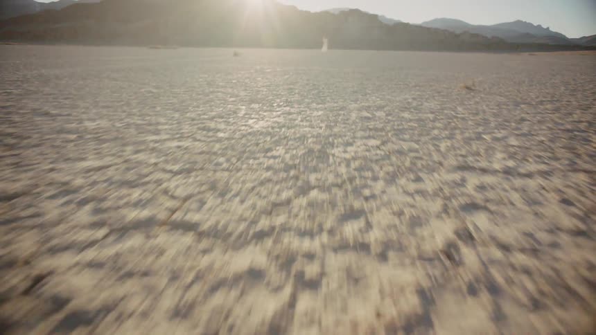 A woman stands in the background of a desert