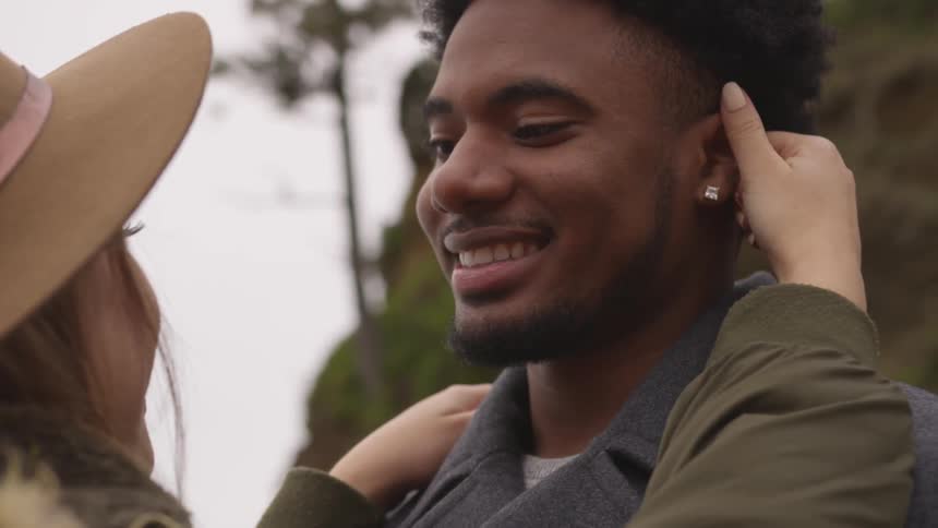 A couple hold each other close while looking at each other and smiling