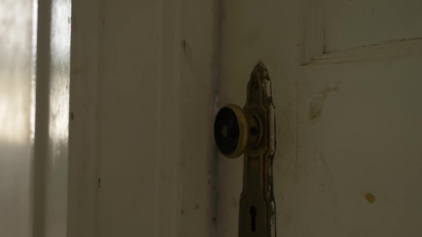 An old dirty door and doorknob being forced open