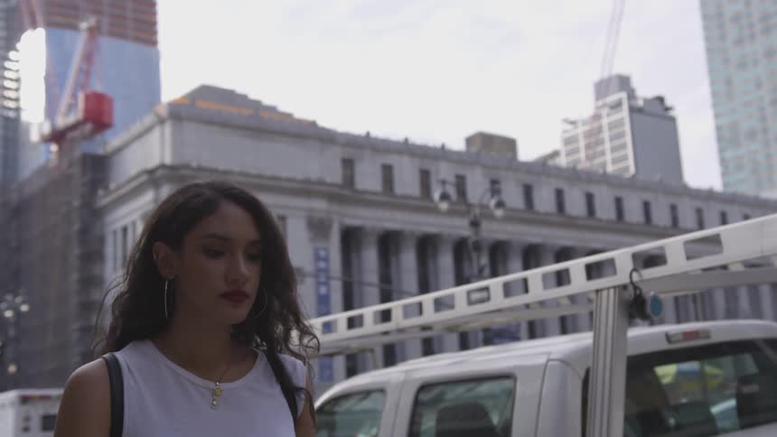 A woman is walking outside in the city