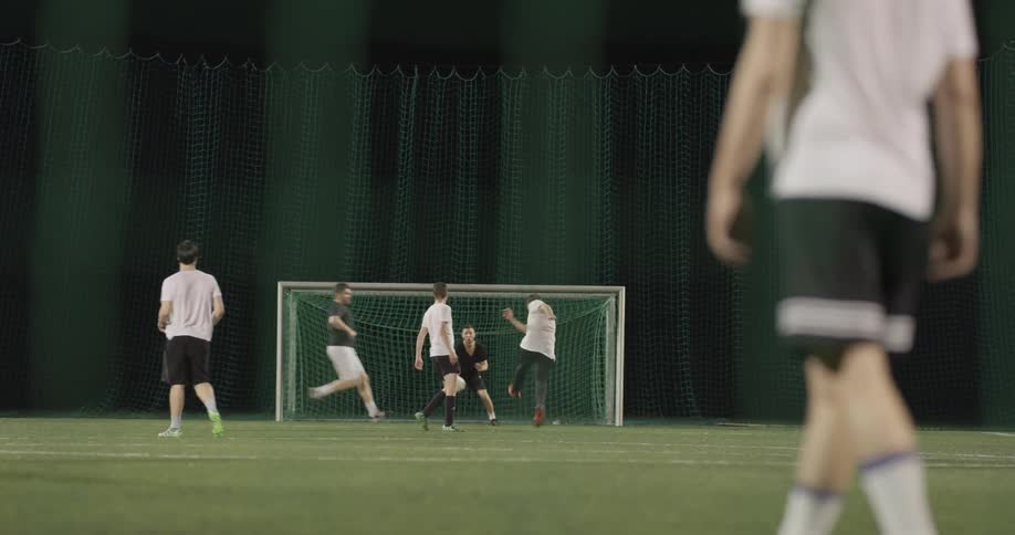 Several men place soccer at night