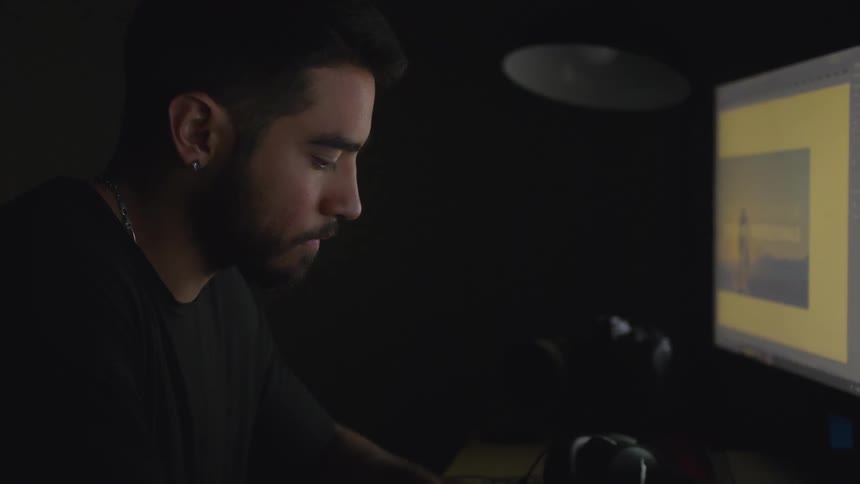 A man working on a computer with the lights off
