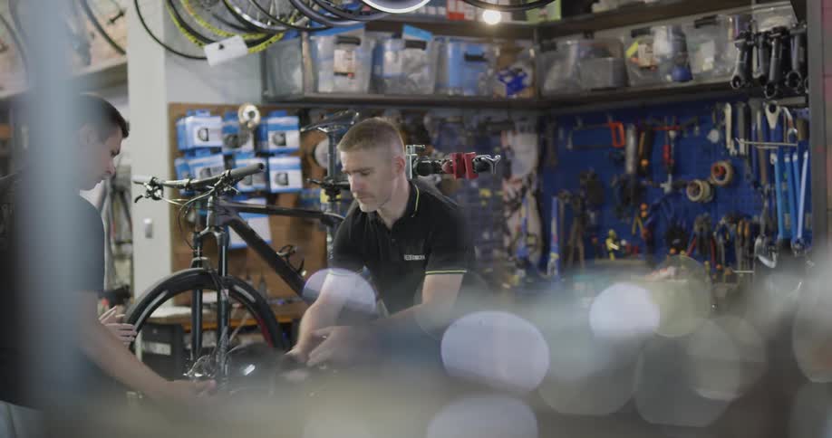 A bicycle shop employee works on a bike