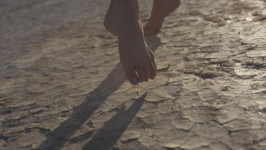 A woman in a dress dancing on hardened clay