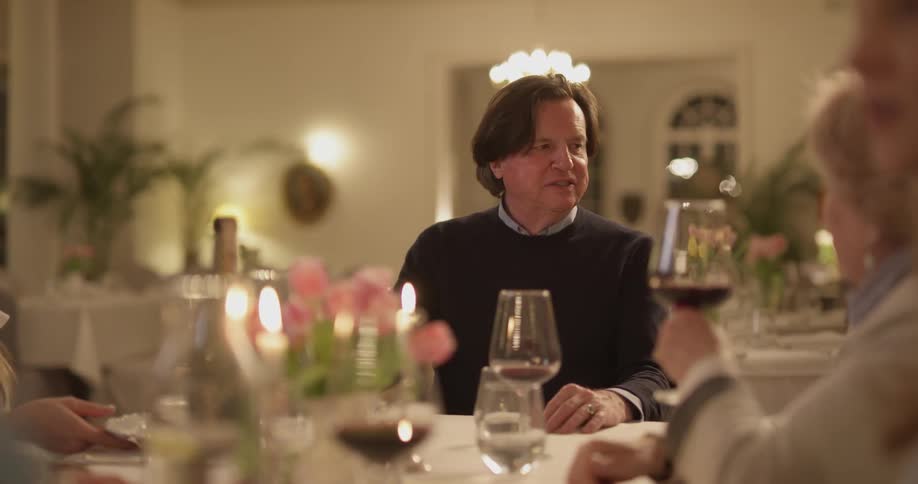 A group of people dine together and drink wine