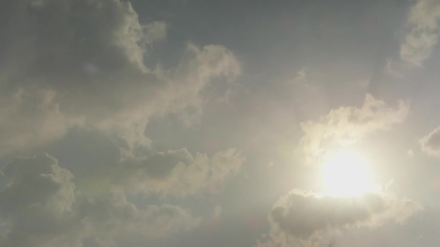 Clouds rolling over the sun in the sky