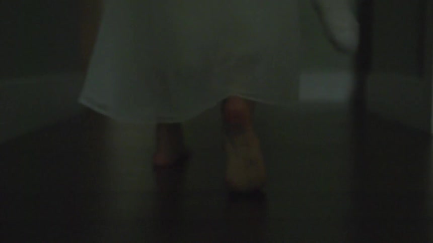 A girl walking down a hall at night