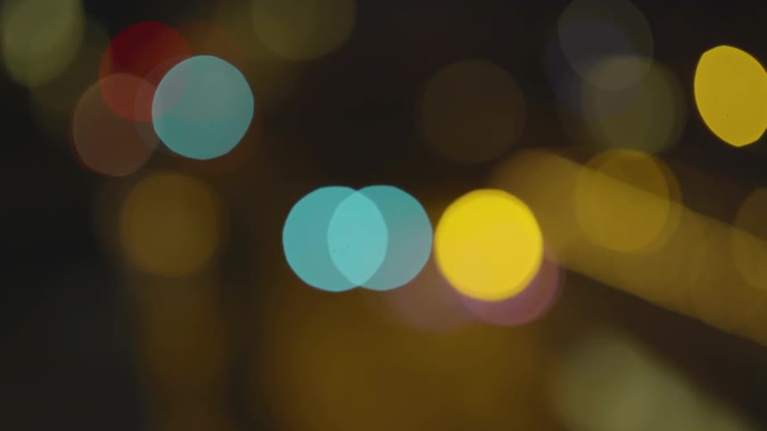 Different colored lights shine from the darkness