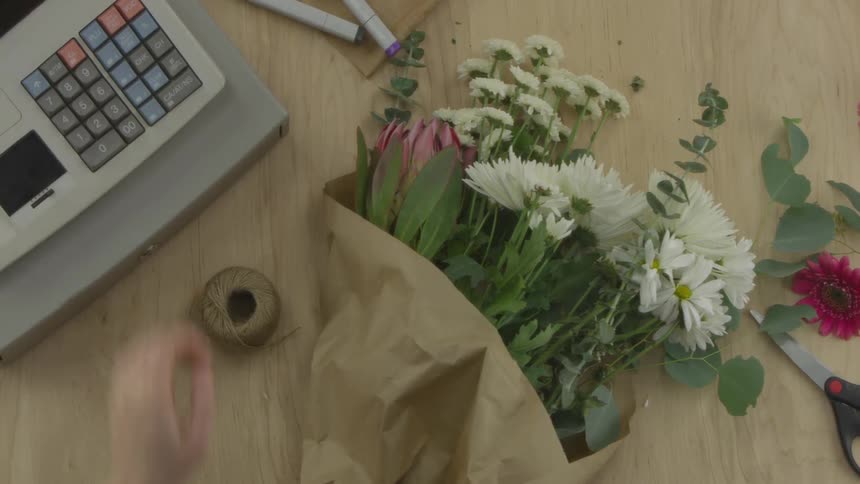 A person ringing up flowers at a store