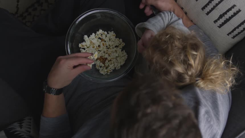 Two people are eating popcorn