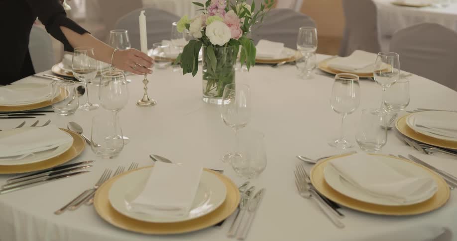 A woman places a candle on a table