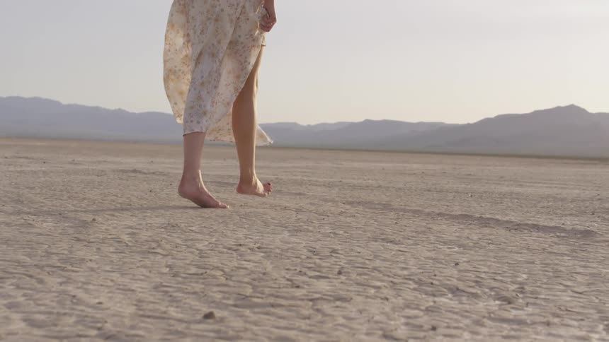 Woman walking barefoot on a desert