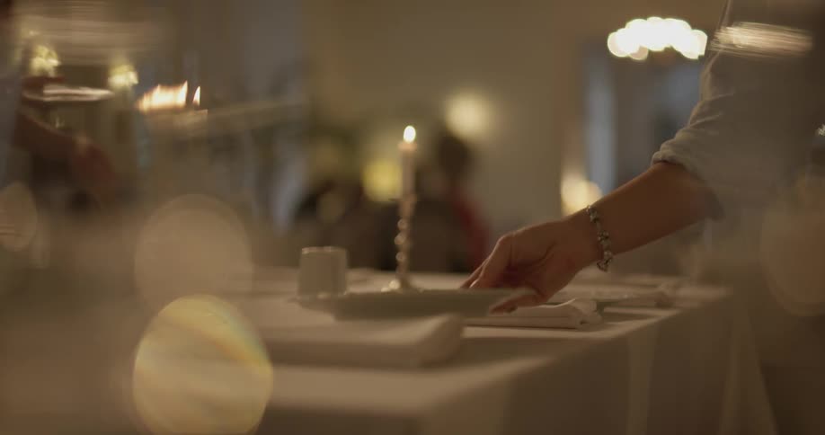A person is setting plates on a table