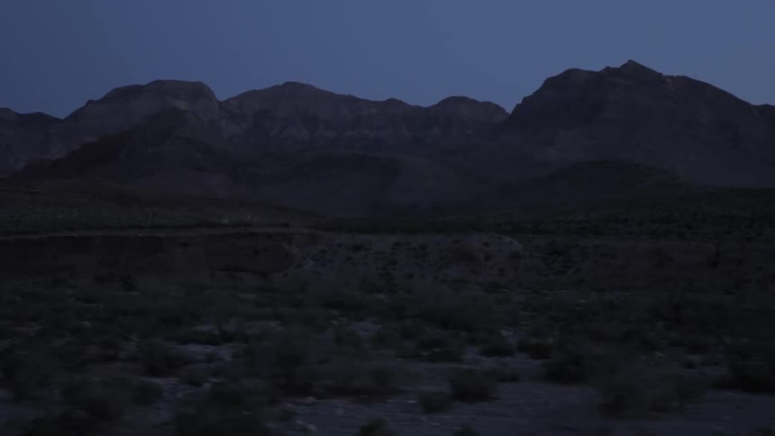 Road borders scrub land and mountains