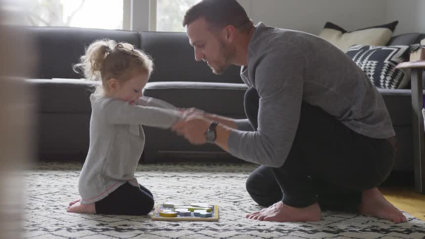 Man and little girl playing in the living room