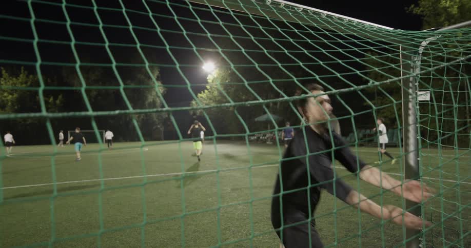 A group of men playing soccer outdoors at night
