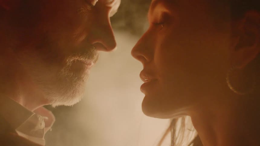 A man and woman kissing in a smoky environment