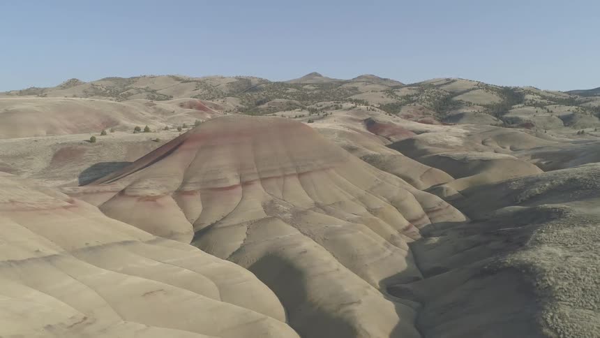 The camera goes around a mesa rock at day
