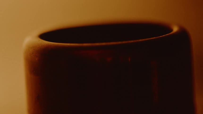 A computer sitting in front of a flickering candle