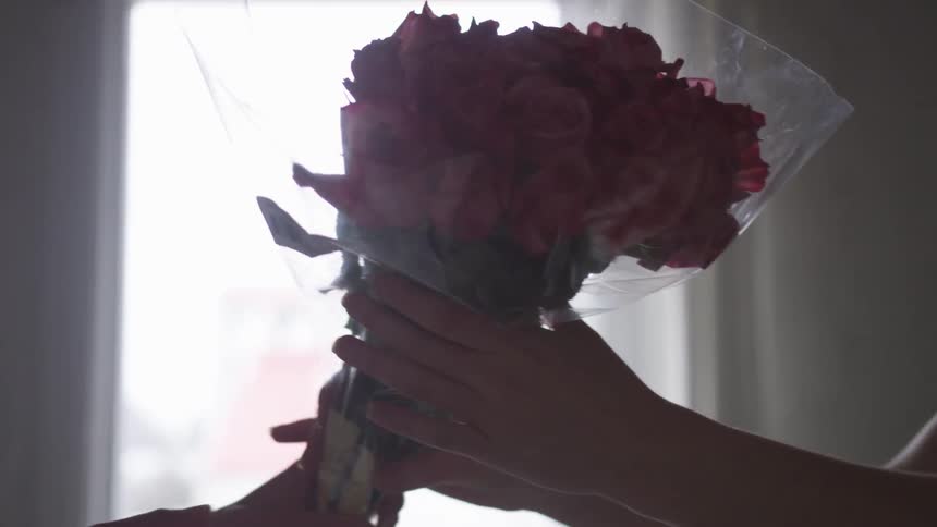 Flower bouquet being handed from one person to another