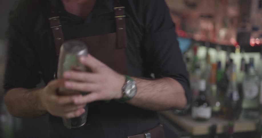 A bartender is shaking a drink