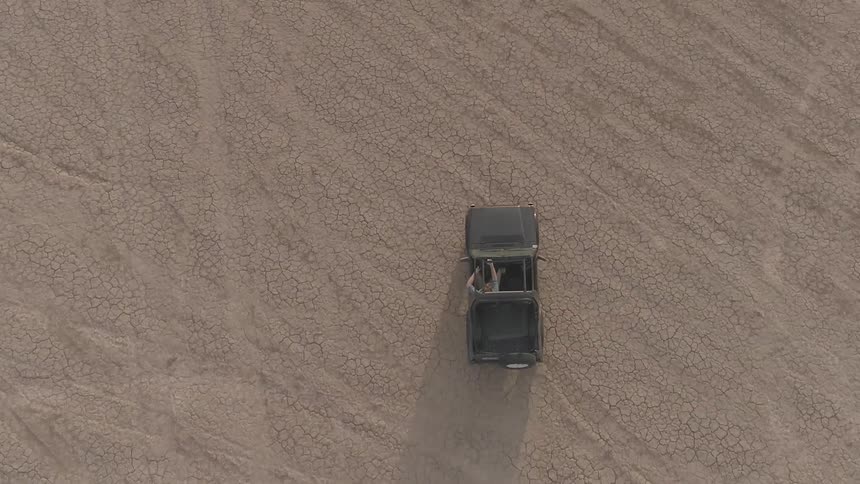 A car driving down a dried out lake bed