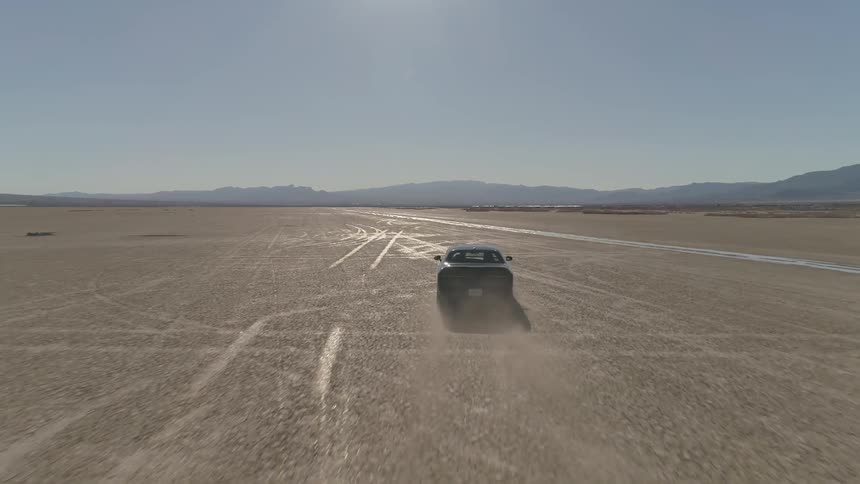 A car driving down a dried lake bed