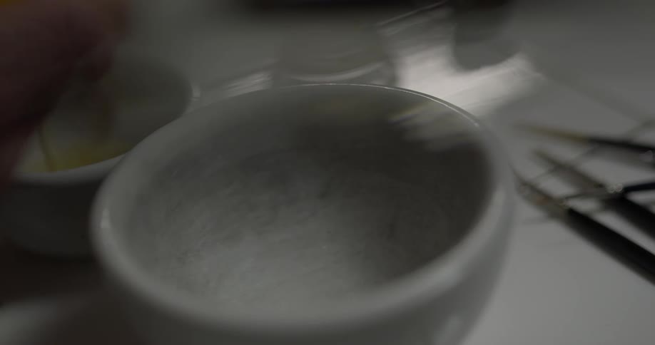 A person putting egg into a bowl
