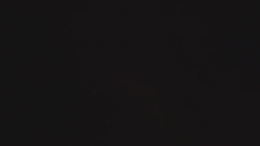 Embers float up into the dark sky