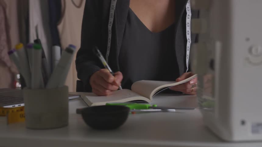 Woman writes in notebook with pen