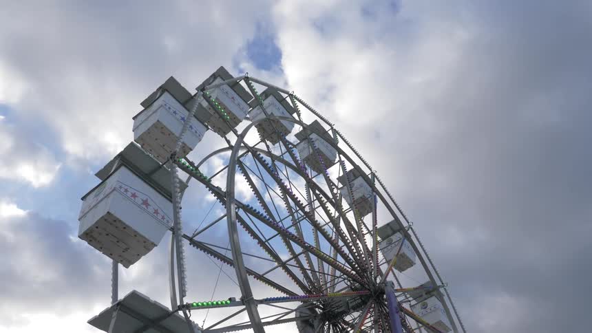 Ferris wheel outside on a bright sunny day with clouds at an amusement park