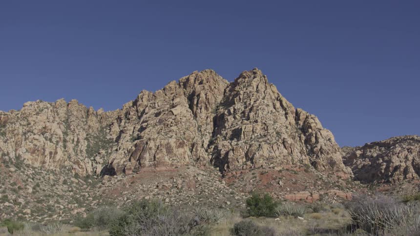 Shrubs and rocks cover a desert landscape