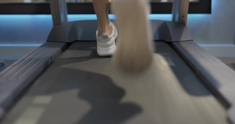 A person running on a treadmill in a gym