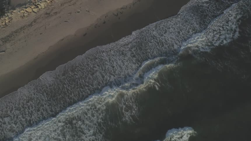 Waves hitting the shore at sunset